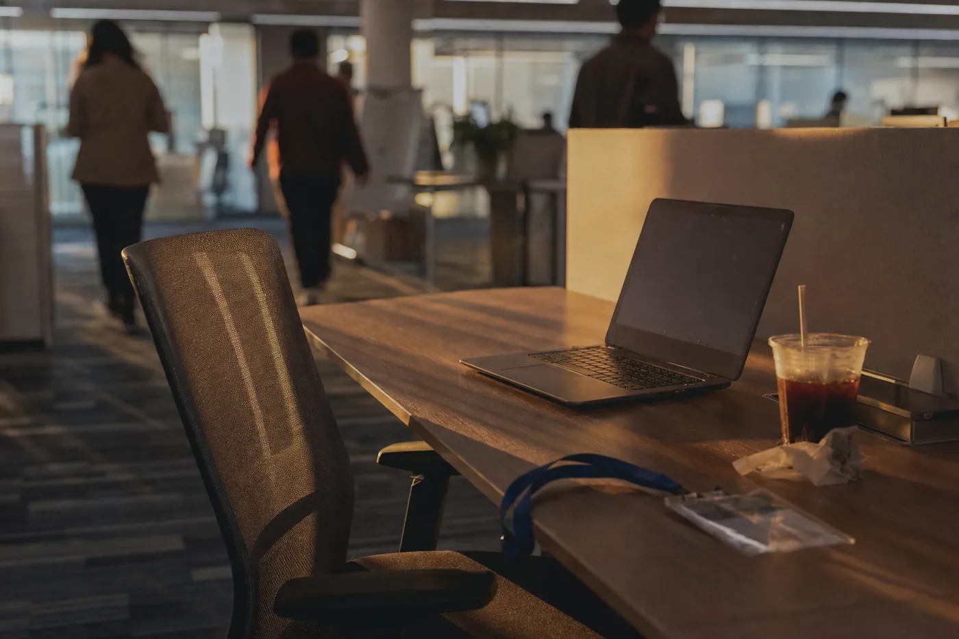 An untouched laptop on an empty desk in early morning light, showing an AI training tool that nobody has adopted