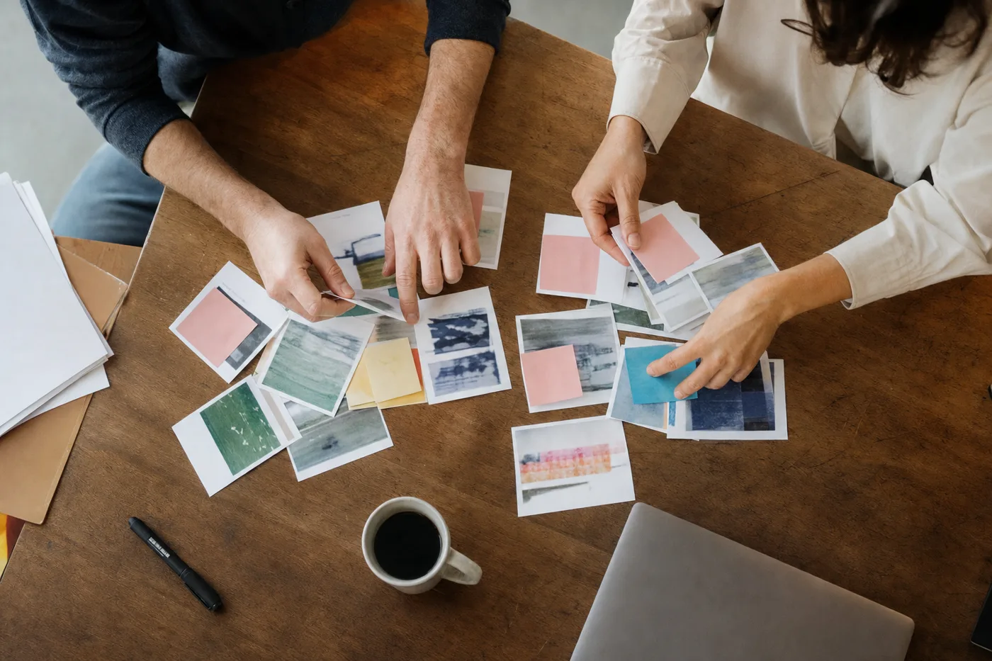 Overhead view of hands sorting mixed printed scenario cards on an office desk, illustrating interleaved practice